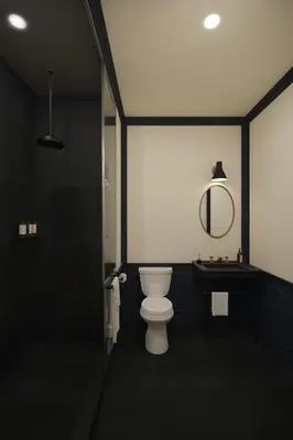 a black bathroom with a toilet and a sink at Gravity Haus Denver in Denver