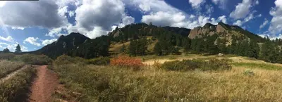 a dirt road in the middle of a field with mountains at Fantastic Classic Family Home in Boulder
