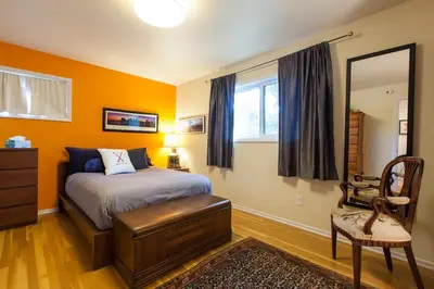 a bedroom with a bed and a mirror and a chair at Fantastic Classic Family Home in Boulder
