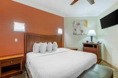 a bedroom with a white bed and a flat screen tv at Best Western Plus Loveland Inn in Loveland