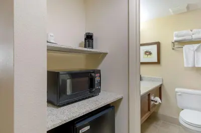 a small bathroom with a microwave on a counter at Best Western Plus Loveland Inn in Loveland