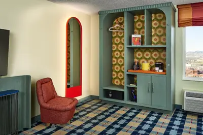 a living room with a chair and a window at the Curtis Denver - A DoubleTree by Hilton Hotel in Denver
