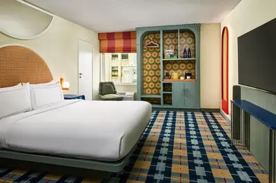 a hotel room with a bed and a kitchen at the Curtis Denver - A DoubleTree by Hilton Hotel in Denver