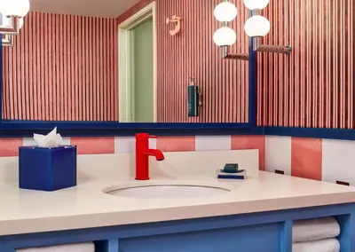 a bathroom with a sink with a red faucet at the Curtis Denver - A DoubleTree by Hilton Hotel in Denver