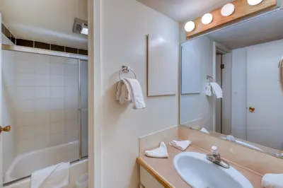 a bathroom with a sink and a mirror and a tub at Wild Irishman 1080 in Dillon