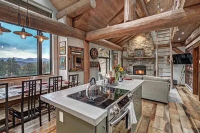a kitchen and living room with a fireplace at SkyRun Cabin cabin in Golden