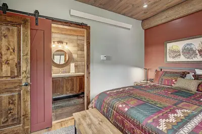 a bedroom with a bed and a mirror at SkyRun Cabin cabin in Golden