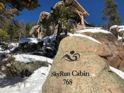 a sign on a rock in front of a house at SkyRun Cabin cabin in Golden