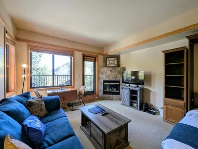 a living room with a blue couch and a table at Slopeside 2773A by SummitCove Lodging in Keystone