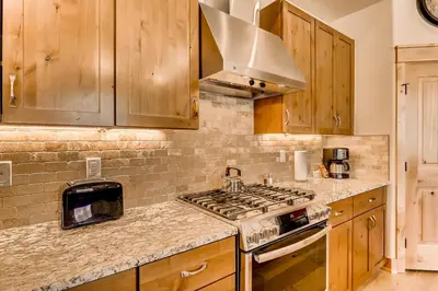 a kitchen with wooden cabinets and a stove top oven at Three-Bedroom Townhouse in Keystone