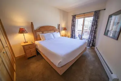 a bedroom with a large white bed and a window at Tenderfoot Lodge 2620 by SummitCove Lodging in Keystone