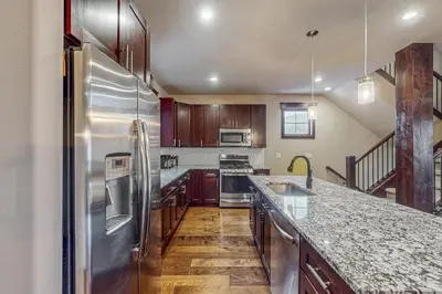 a kitchen with a stainless steel refrigerator and wooden cabinets at Keystone Townhome in Keystone