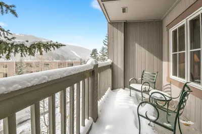 two benches on a balcony covered in snow at Expedition Station 8597 by SummitCove Lodging in Keystone
