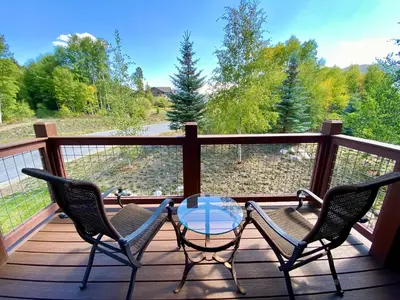 a patio with two chairs and a glass table on a deck at Frey Gulch 58 by SummitCove Lodging in Keystone