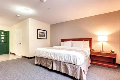 a large bedroom with a large bed and a nightstand at Suburban Studios Westminster Denver North in Westminster