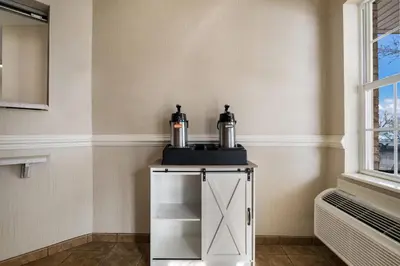a small white cabinet with two bottles on top of it at Suburban Studios Denver Central-Arvada in Arvada