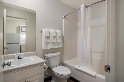 a bathroom with a toilet and a sink and a shower at Suburban Studios Denver Central-Arvada in Arvada