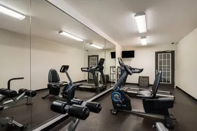 a gym with tread machines and a mirror at Suburban Studios Denver Central-Arvada in Arvada