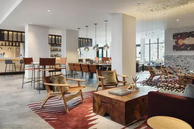 a lobby with chairs and tables and a bar at AC Hotel Frisco Colorado in Frisco