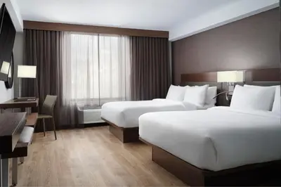a hotel room with two beds and a desk at AC Hotel Frisco Colorado in Frisco