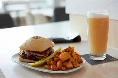 a plate with a sandwich and fries and a glass of beer at AC Hotel Frisco Colorado in Frisco