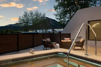 a pool with chairs and a hot tub on a patio at AC Hotel Frisco Colorado in Frisco