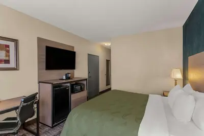 a hotel room with a bed and a flat screen tv at Quality Inn Denver Northeast Brighton in Brighton