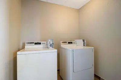 a laundry room with a refrigerator and a washer at Quality Inn Denver Northeast Brighton in Brighton