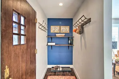 a hallway with a blue wall and a wooden door at Outdoor Kitchen and Swim Spa 1-Acre Grand Lake Home in Grand Lake