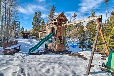 a playground in the snow with a slide at Outdoor Kitchen and Swim Spa 1-Acre Grand Lake Home in Grand Lake