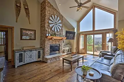 a living room with a couch and a fireplace at Golf, Ski and Hike Luxe Group Getaway in Granby! in Granby