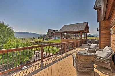 a deck with chairs and tables on a house at Golf, Ski and Hike Luxe Group Getaway in Granby! in Granby