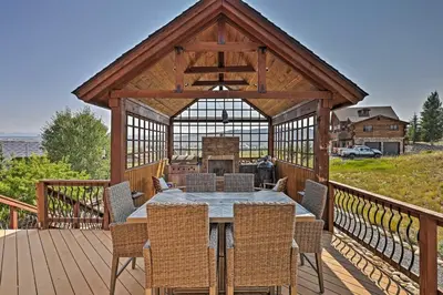 a wooden gazebo with a table and chairs on a deck at Golf, Ski and Hike Luxe Group Getaway in Granby! in Granby