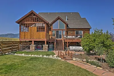 a large wooden house with a large deck at Golf, Ski and Hike Luxe Group Getaway in Granby! in Granby