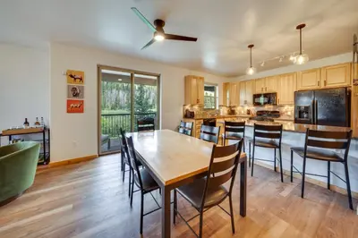 an open kitchen with a wooden table and chairs at Four-Season Winter Park Condo with Pool Access! in Winter Park