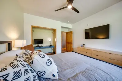 a bedroom with a large bed with a flat screen tv at Four-Season Winter Park Condo with Pool Access! in Winter Park