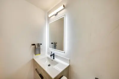a white bathroom with a sink and a mirror at Four-Season Winter Park Condo with Pool Access! in Winter Park