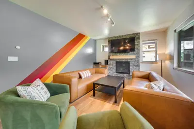 a living room with two couches and a rainbow at Four-Season Winter Park Condo with Pool Access! in Winter Park