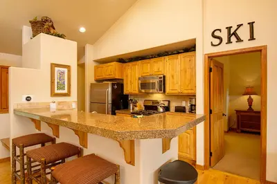 a kitchen with wooden cabinets and a counter top at 45 Reunion Court - Rendezvous in Fraser