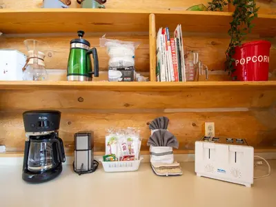 a kitchen counter with a coffee maker and books at Miles Behind Log Cabin in Fraser