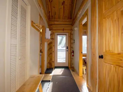 a hallway with wooden ceilings and a door with a door at Miles Behind Log Cabin in Fraser