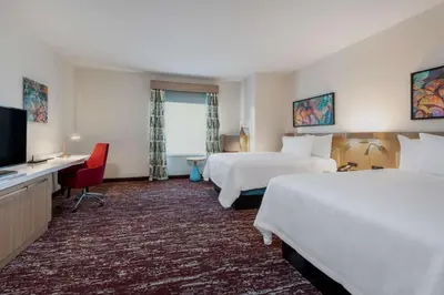 a hotel room with two beds and a flat screen tv at Hilton Garden Inn Longmont in Longmont