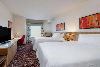 a hotel room with two beds and a flat screen tv at Hilton Garden Inn Longmont in Longmont