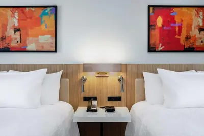 a hotel room with two beds and a phone on a table at Hilton Garden Inn Longmont in Longmont