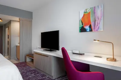 a hotel room with a desk with a tv at Hilton Garden Inn Longmont in Longmont