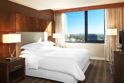a bedroom with a large bed and a large window at Sheraton Denver West Hotel in Lakewood