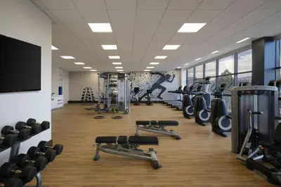 a gym with several rows of treadmills and weights at Sheraton Denver West Hotel in Lakewood