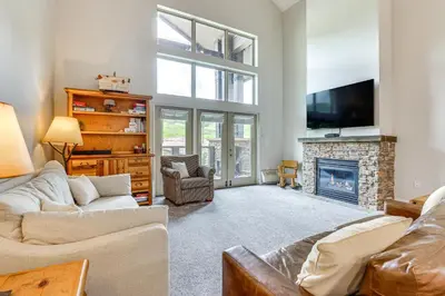 a living room with a fireplace and a tv at Ski-InandSki-Out Granby Penthouse with Mountain Views! in Granby