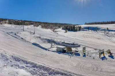 a snow covered ski slope with a ski lift at Ski-InandSki-Out Granby Penthouse with Mountain Views! in Granby