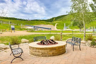 a fire pit in a park with two chairs at Ski-InandSki-Out Granby Penthouse with Mountain Views! in Granby